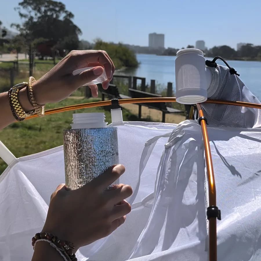 Hands replacing a Malaise trap collection bottle.
